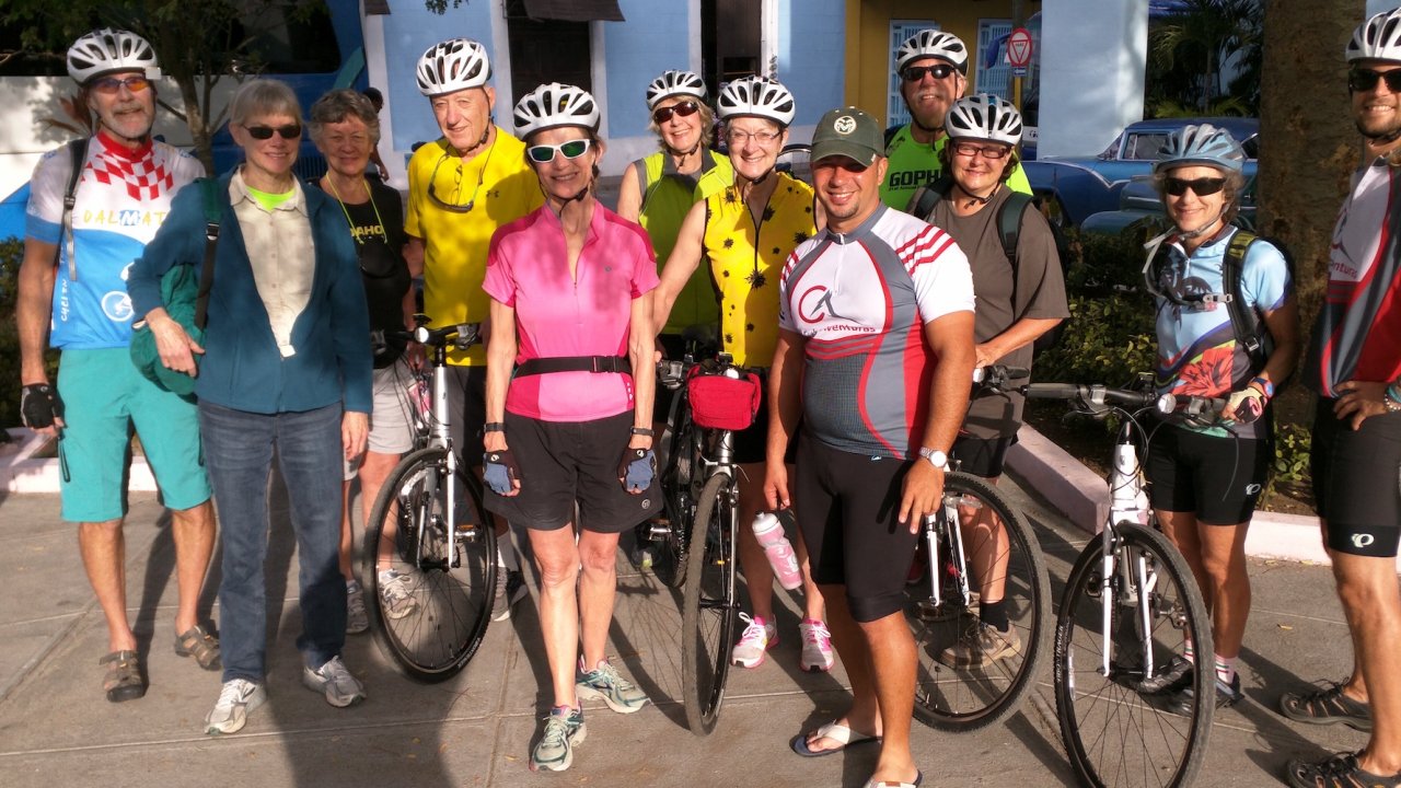 People smiling and standing next to their bikes in Cuba