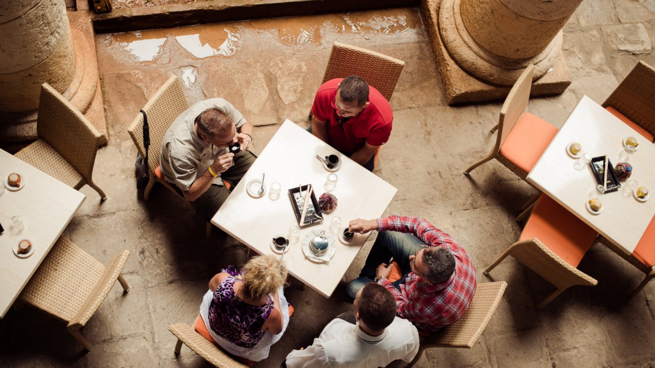 A group of people sitting around a table at a restaurant in Cuba