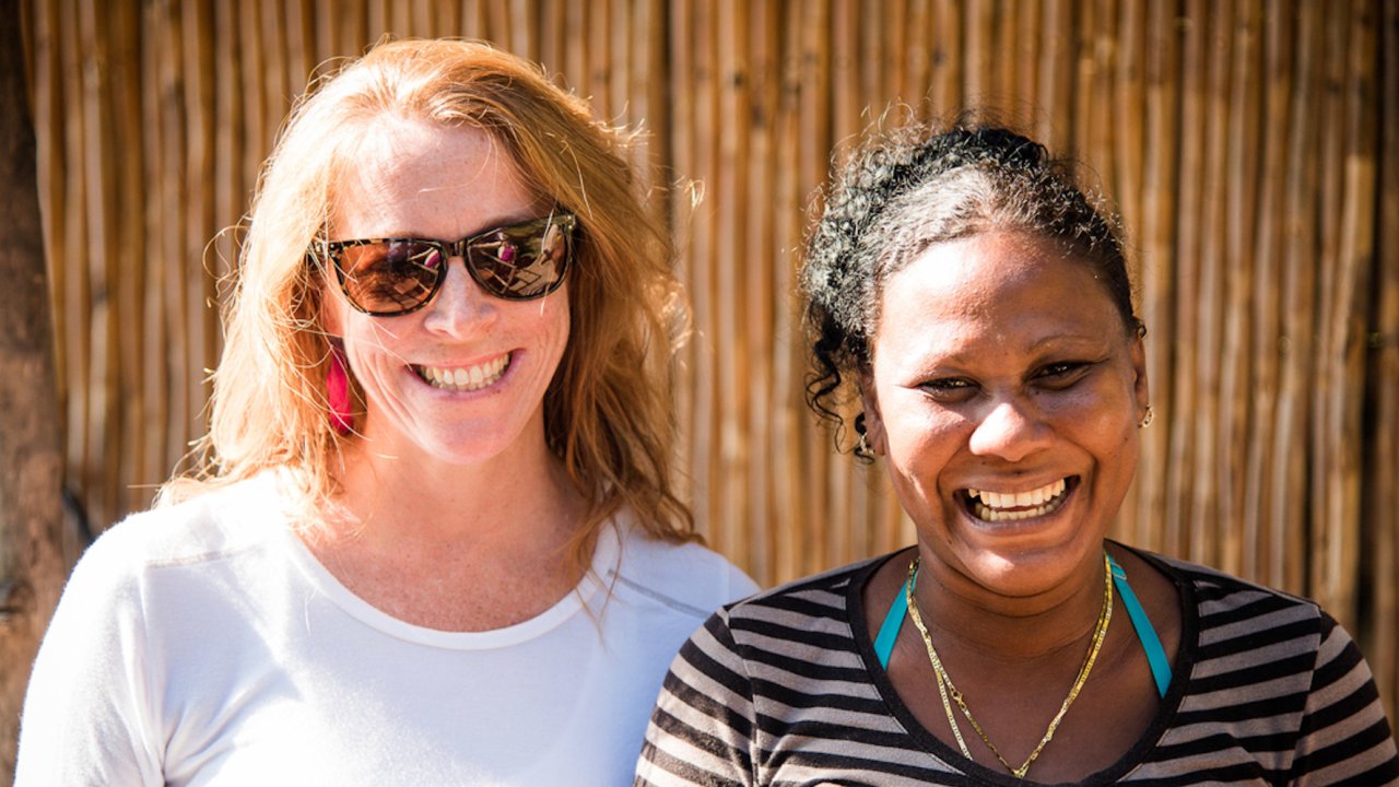 A visitor and a local Cuban smile for a photo.