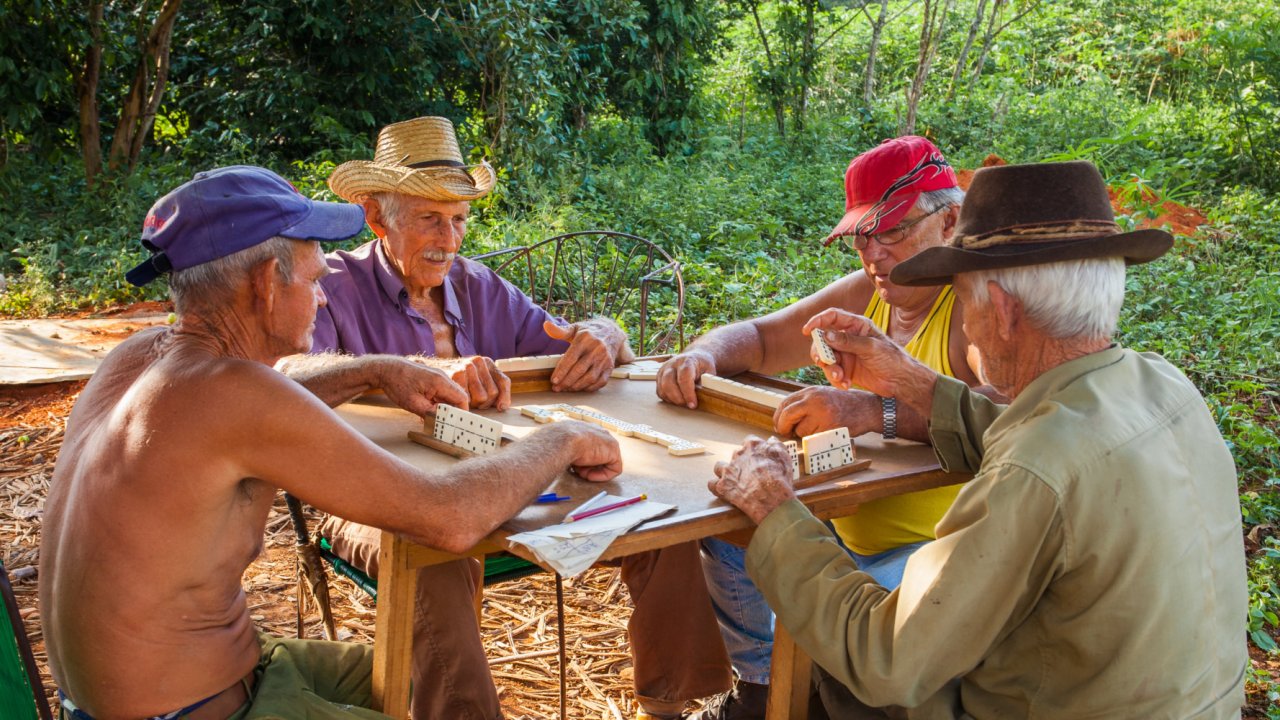 A group of people sitting around a table playing a game in Vinales Cuba