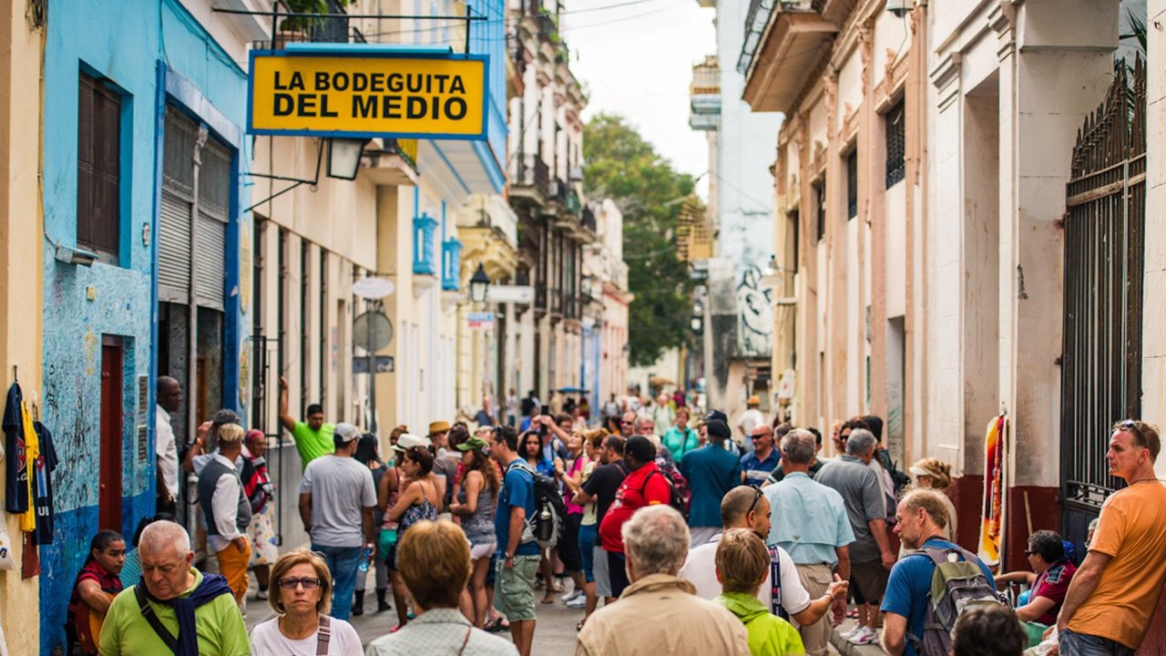 Tourists crowd the colorful streets of Havana, Cuba, during a stop on a guided bike tour of Cuba, showcasing the vibrant culture and energy of cycle Cuba tours.