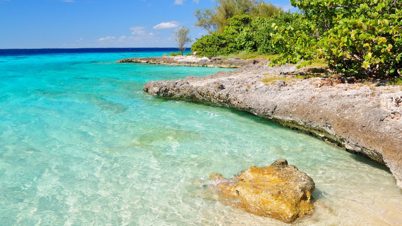 Turquoise waters and rocky shoreline along the Bay of Pigs in Eastern Cuba, showcasing the island’s stunning coastal scenery.