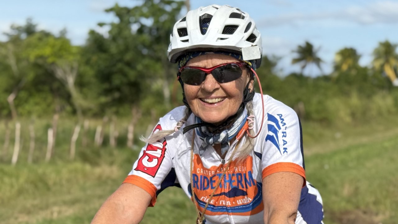 Smiling cyclist wearing a helmet during a guided Cuba bike tour through rural countryside, highlighting active Cuba travel experiences