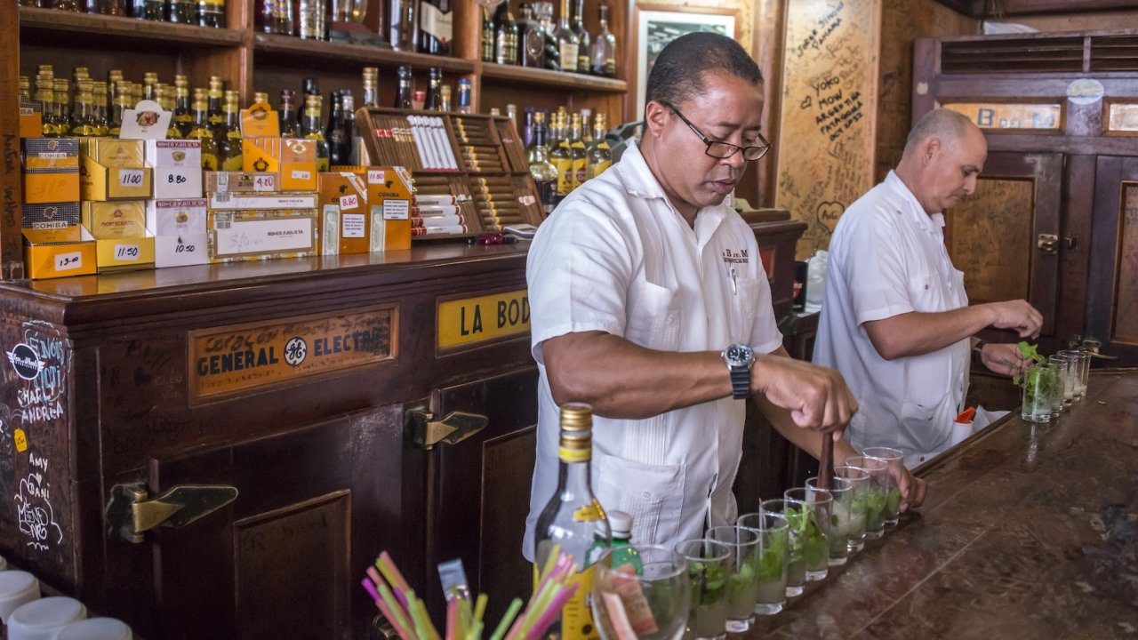 Bartenders prepare mojitos at La Bodeguita del Medio in Havana, Cuba — a must-visit stop on a weekend in Havana travel tour from the US.