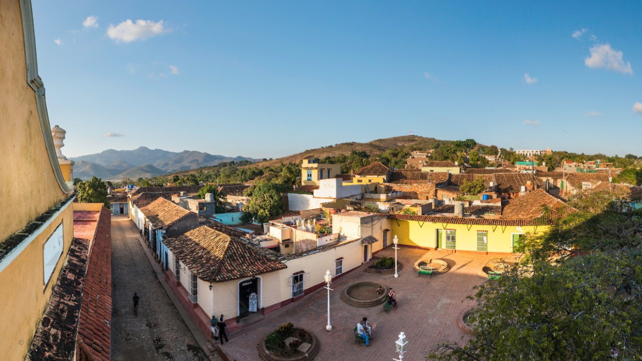 Panoramic shot of a quaint and colorful town in Cuba surrounded by greenery