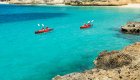 Two red sea kayaks atop crystal clear turquoise water in the Caribbean