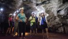 A group of people exploring a cave with hard hats and headlamps