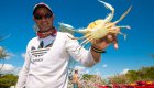 Close up of a man holding a crab on the beach in Cuba
