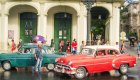 A red and green classic old school cars in front of stone arches in Havana, Cuba