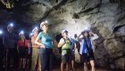 A group of tourists in Cuba in a cave with headlamps learning about the tunnel