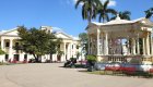 Neoclassical buildings and a yellow-columned gazebo in a central square in Santa Clara, Cuba, a city rich in history and culture.