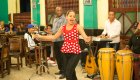 A woman dancing and singing while a band of men play instruments behind her