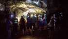 A group of people wearing hard hats and head lamps while in a cave in Cuba