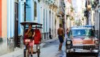 Colorful street with an old red car on the left side in Havana Cuba