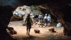 People walking into a cave underground in Cuba