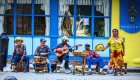 A group of six people in a line playing instruments on the streets of Cuba