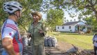 A Cuban farmer talks to cyclists in a rural village, offering an authentic cultural experience during a bicycle tour of Cuba through scenic countryside routes.