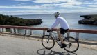 Cyclist riding along Cuba’s scenic coastline on a bike tour, showcasing the relaxed pace and beauty of Cuba travel by bicycle