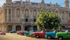 colorful classic cars lined up on cuban street