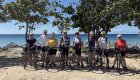Travelers posing with bicycles on a beach during a Cuba bike tour, blending outdoor adventure with cultural Cuba tours