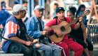 Local Cuban musicians performing traditional music with maracas and guitar in a lively Havana street scene.