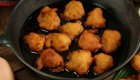 Multiple fried corn fritters in a cast iron pan in Cuba. 
