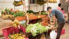 Local man shopping for seasonal fruits and vegetables at a bustling street market in Havana during a Cuban food tour.