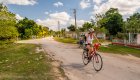 A person on a bike on a paved road in Cuba on a sunny day