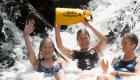 Travelers cooling off beneath a waterfall in Eastern Cuba, enjoying an outdoor adventure during a Cuba Unbound excursion.