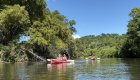 Kayakers paddling a calm river during a guided Cuba tour, highlighting the diverse outdoor activities available in Cuba travel experiences
