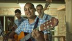 Local Cuban musicians playing guitar and singing during an evening cultural excursion in Havana, Cuba.