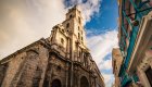 Historic stone church and colorful colonial buildings in Old Havana, Cuba, showcasing the city’s classic architecture.