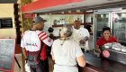 Travelers interacting with locals and ordering drinks at a café stop on a Cuba guided tour.