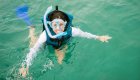 Happy snorkeler in mask and fins floating in warm clear water while snorkeling in Cuba.
